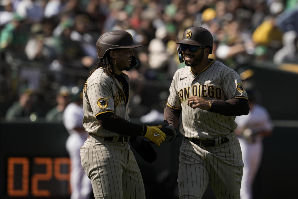 San Diego Padres' Trent Grisham, right, celebrates with Luis Campusano, left, after they scored against the Oakland Athletics on the throwing error by first baseman Ryan Noda during the fifth inning of a baseball game, Saturday, Sept. 16, 2023, in Oakland, Calif. Brett Sullivan reached first on the play. (AP Photo/Godofredo A. Vásquez)