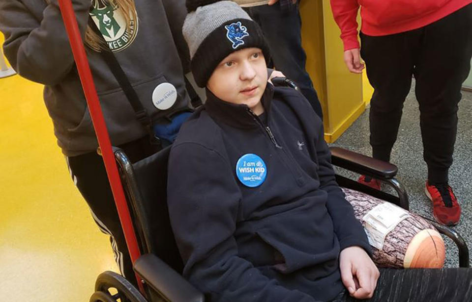 Michael Choroszy, 11, pictured in a wheelchair wearing a Make-A-Wish badge.