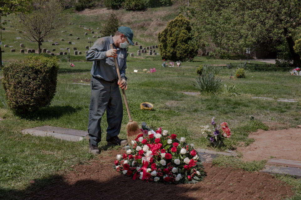 Social distancing regulations have made funerals lonely and rare. On May 4, Janusz Karkos tends the grave of a COVID-19 victim at Brooklyn's Green-Wood Cemetery. | Natalie Keyssar for TIME