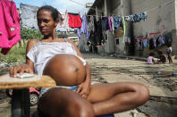 <p>Nivia, who is nearly nine months pregnant, sits outside her home located in the Mangueira favela on May 2, 2017 in Rio de Janeiro. (Photo: Mario Tama/Getty Images) </p>