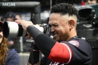 Washington Nationals' Ildemaro Vargas uses a photographers camera during the seventh inning of an exhibition baseball game against the Washington Nationals Futures, Tuesday, March 26, 2024, in Washington. (AP Photo/Nick Wass)