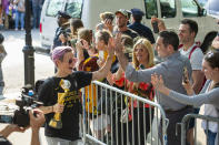 United States women's soccer team member Megan Rapinoe, left, greets fans as she walks to a hotel with the World Cup trophy in her hand Monday, July 8, 2019, in New York. The city will honor the team with a parade on Wednesday. (AP Photo/Corey Sipkin).