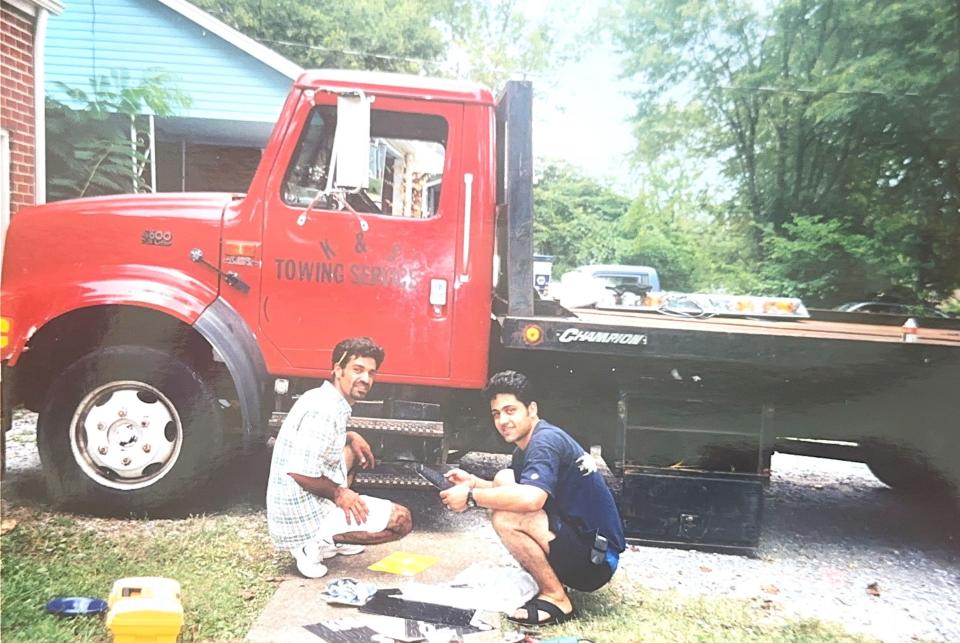 Brentwood businessman Sammy Poori, right, works on a tow truck that he and his brother-in-law, Kamran Hasouri bought together as business partners.
