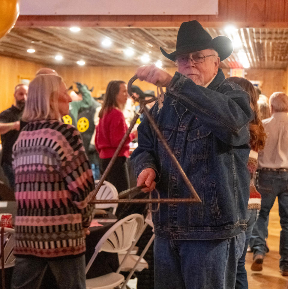 A member of the Coors Cowboy Club chimes the dinner triangle Saturday at the 100 Club of the Texas Panhandle's annual Bandfest in Bushland.