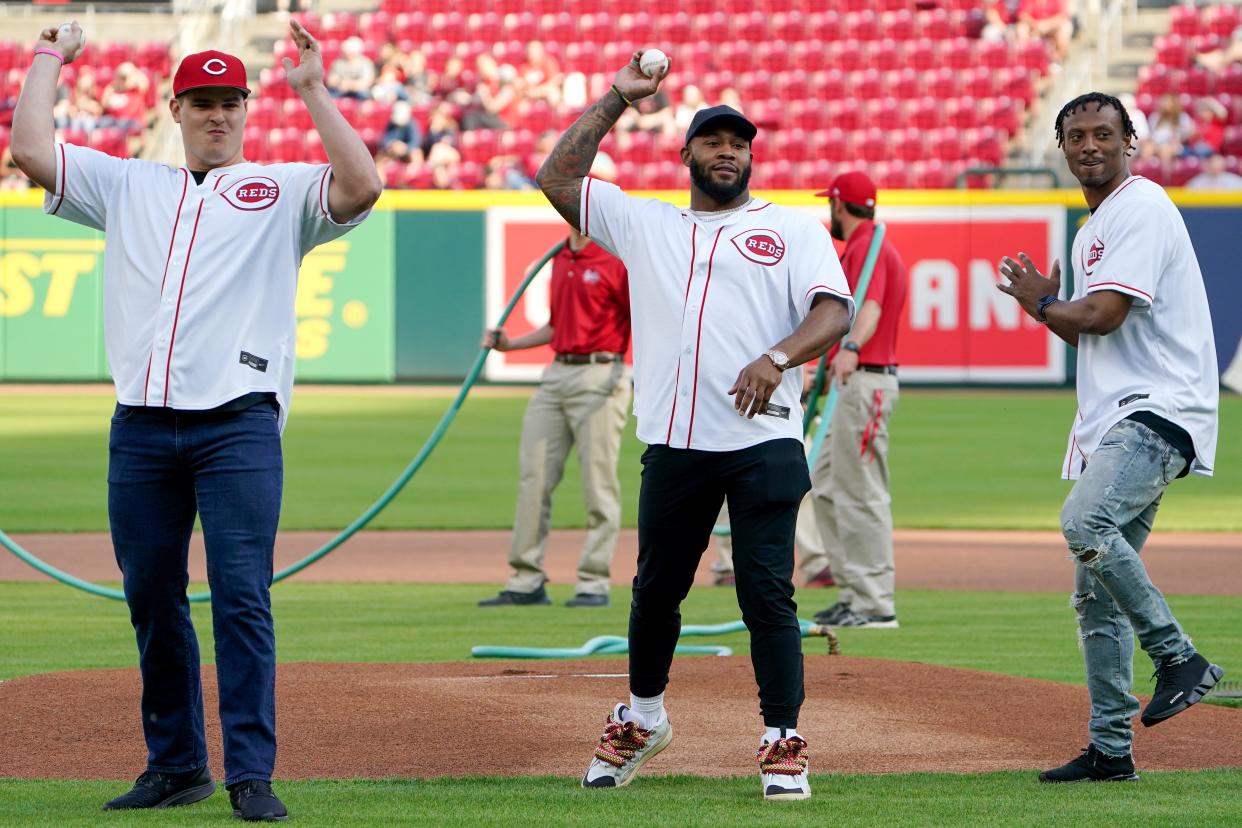 Cincinnati Bengals defensive end Trey Hendrickson, safety Vonn Bell and cornerback Eli Apple throw out a simultaneous first pitch before a baseball game between the St. Louis Cardinals and the Cincinnati Reds, Friday, April 22, 2022, at Great American Ball Park in Cincinnati. 