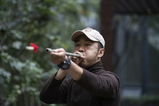 Chinese pet detective Sun Jinrong tests his blowdart as he prepares to search for a missing cat in a residential compound in Beijing