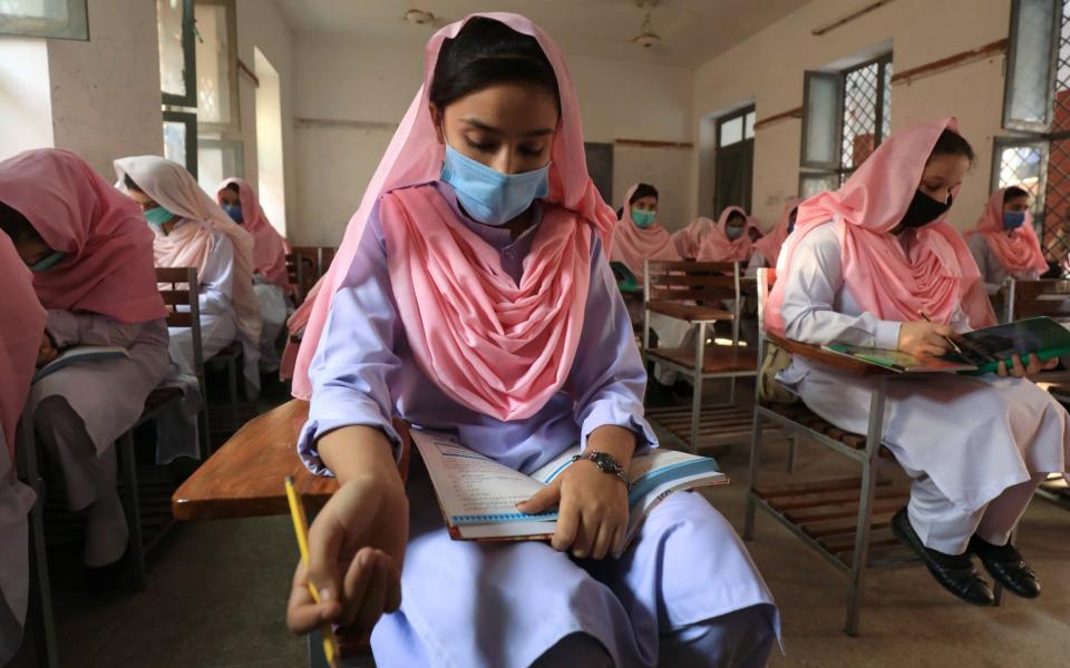 Students wear protective masks and maintain safe distance as they attend a class, after the government allowed the reopening of schools in Peshawar, Pakistan - Reuters