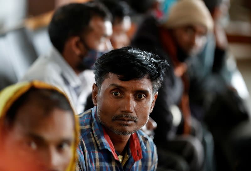 Indian migrant workers wait inside a railway station to board trains to their home states, on outskirts of Srinagar