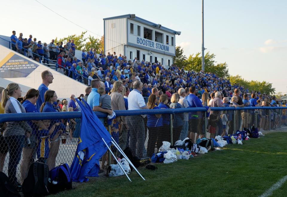 Marion Local football fans stand during the playing of the national anthem before a Sept. 22 game against Versailles.