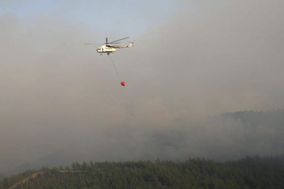 A water-dropping aircraft flies over the Bordubet region, near Marmaris, western Turkey, Thursday, June 23, 2022. Water-dropping aircraft from Azerbaijan and Qatar on Friday joined the fight against a wind-stoked wildfire that burned for a fourth day near a popular resort in southwestern Turkey. Turkey's forestry minister meanwhile, said the fire may be close to being contained but said the wind still posed a risk. (AP Photo)