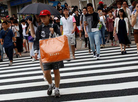 A woman carries a shopping bag at a shopping district in Tokyo, Japan August 14, 2017. REUTERS/Kim Kyung-Hoon