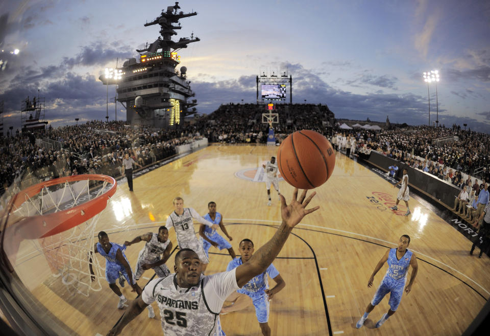 FILE - In this image taken with a fisheye lens, Michigan State center Derrick Nix (25) grabs a rebound in front of North Carolina forward John Henson (31), right, during the first half of the Carrier Classic NCAA college basketball game aboard the USS Carl Vinson, Friday, Nov. 11, 2011, in Coronado, Calif. They're going to try to play college basketball on an aircraft carrier again, and Tom Izzo and the Michigan State Spartans will get a return trip to San Diego Bay to face Gonzaga on the flight deck of the USS Abraham Lincoln on Nov. 11, 2022. (AP Photo/Mark J. Terrill, File)