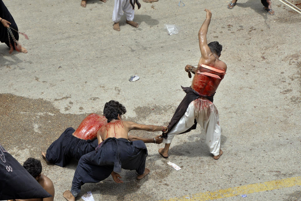 Shiite Muslims flagellate themselves with knifes on chains during a procession to mark Ashoura in Hyderabad, Pakistan, Saturday, July 29, 2023. Ashoura is the Shiite Muslim commemoration marking the death of Hussein, the grandson of the Prophet Muhammad, at the Battle of Karbala in present-day Iraq in the 7th century. (AP Photo/Pervez Masih)