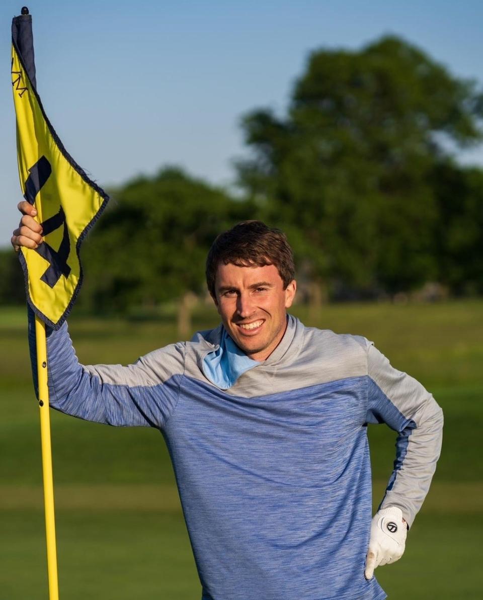 Matt Goodson poses with a flag pole after completing 100 holes of golf.