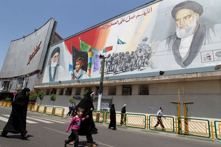 Iranian women walk past a mural depicting Iran's supreme leader Ayatollah Ali Khamenei (L) and late revolutionary leader Ayatollah Ruhollah Khomeini (R) at Enghelab (Revolution) Square in Tehran on April 27, 2012. The Vatican, Iran and other religious states are resisting efforts by a UN conference to demand tougher global standards to prevent violence against women and children