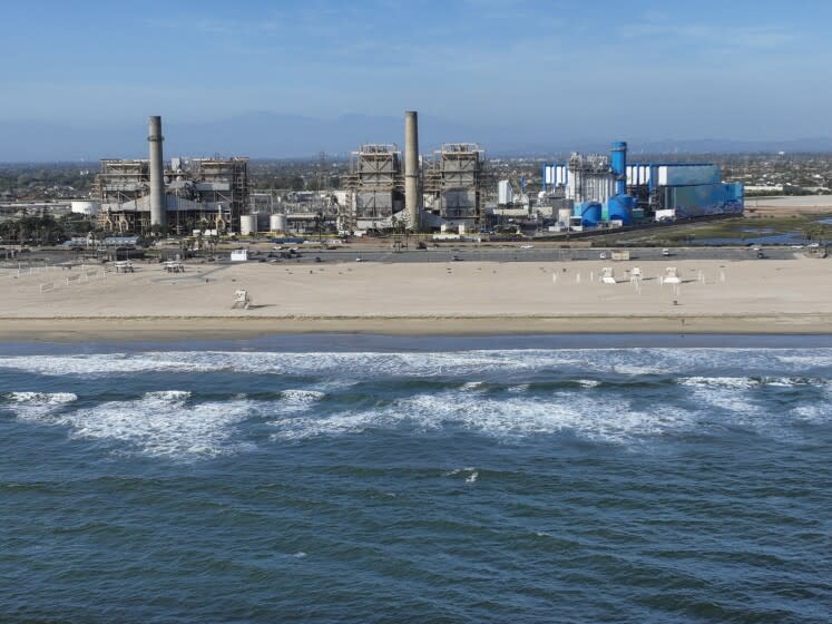 Huntington Beach, CA - April 5: An aerial view of the AES Huntington Beach Energy Center, the proposed site of the Poseidon Desalination Plant, which would draw ocean water through an existing intake pipe. In the background is neighboring residential community, Edison Community Park, Edison High School, ASCON toxic State superfund cleanup site, the proposed Magnolia Tank Farm Lodge, restaurants, and retail, upper right, the Huntington Beach Wetlands, middle right, and Huntington State Beach. Photo taken Tuesday, April 5, 2022. The partially retired Huntington Beach Generating Station consists of four generating units but only unit 2 is still in commercial operation as a legacy unit and has an extension to operate through the end of 2023, issued by the California State Water Boards. Unit 2 runs to support peak demands and has a net output capacity of 225 megawatts. The 644 MW combined cycle gas turbine generator, shown in blue and white, began operation on June 25, 2020. Environmental groups have fought Poseidon, arguing that it is privatizing a public resource, has failed to adapt an old proposal to new state ocean protections from killing sea life and that the company is trying to fill a need that doesn't exist, uses too much natural gas energy. Environmental justice activists say water rates could be raised as much as $6 per month. Supporters say ocean desalination as an inexhaustible, local supply for a region that imports much of its water from increasingly unreliable, distant sources. Another stumbling block for Poseidon is state requirements to mitigate the project's harm to the marine environment. Poseidon would draw 106 million gallons a day of seawater through the huge offshore intake pipe, which would be screened, and use reverse osmosis membranes to rid the seawater of salt and impurities. That process would produce 56 million gallons a day of brine concentrate - roughly twice as salty as the ocean - which would be dumped back into the Pacific via a 1,500-foot discharge pipe equipped with outfall diffusers to promote mixing and dilution. The intake and discharge operations will take a toll on plankton, which plays a crucial role in the marine food chain, killing an estimated 300,000 microscopic organisms a day. (Allen J. Schaben / Los Angeles Times)