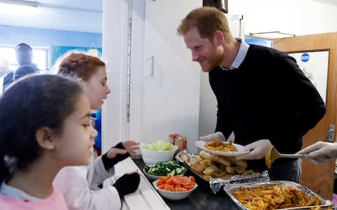 The Duke of Sussex dishes up a hot lunch for children at Streatham Youth and Community Trust - Credit: Chris Jackson