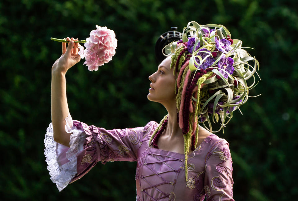 <p>Gemma Sadler models a fabulous Georgian costume, including a wig made from flowers and foliage created by Florist of the Year Helen James, during the staging day for the 2021 Harrogate Autumn Flower Show at Newby Hall, near Ripon. Picture date: Thursday September 16, 2021.</p>
