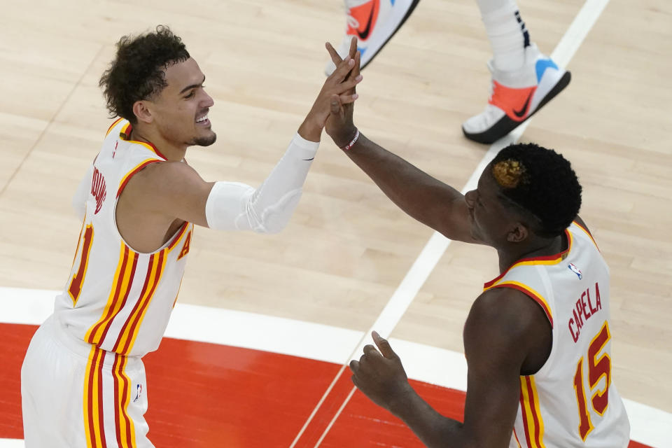 Atlanta Hawks guard Trae Young (11) and Atlanta Hawks center Clint Capela (15) celebrate during the second half of an NBA basketball game against the New Orleans Pelican Tuesday, April 6, 2021, in Atlanta. (AP Photo/John Bazemore)