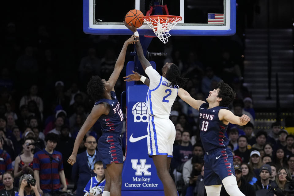 Kentucky's Aaron Bradshaw, center, goes up for a shot against Pennsylvania's Eddie Holland III, left, and Nick Spinoso during the first half of an NCAA college basketball game, Saturday, Dec. 9, 2023, in Philadelphia. (AP Photo/Matt Slocum)