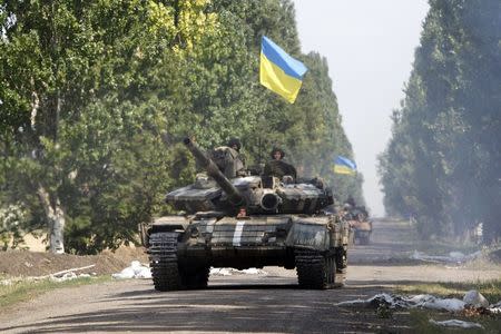 Ukrainian tanks move along a road near Eastern Ukrainian village of Novoselivka Persha July 31, 2014. REUTERS/Valentyn Ogirenko