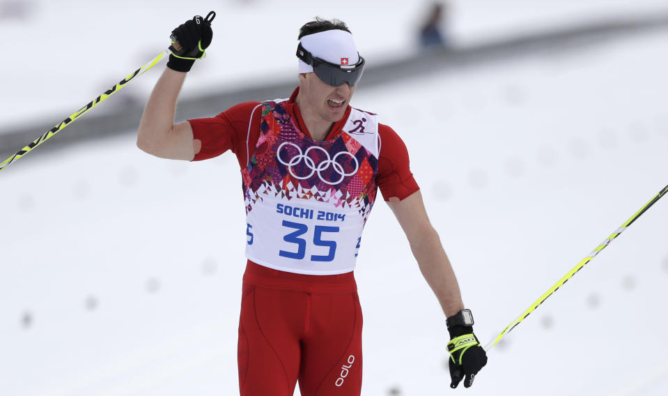 Switzerland's Dario Cologna crosses the finish line to win the gold during the men's 15K classical-style cross-country race at the 2014 Winter Olympics, Friday, Feb. 14, 2014, in Krasnaya Polyana, Russia. (AP Photo/Matthias Schrader)