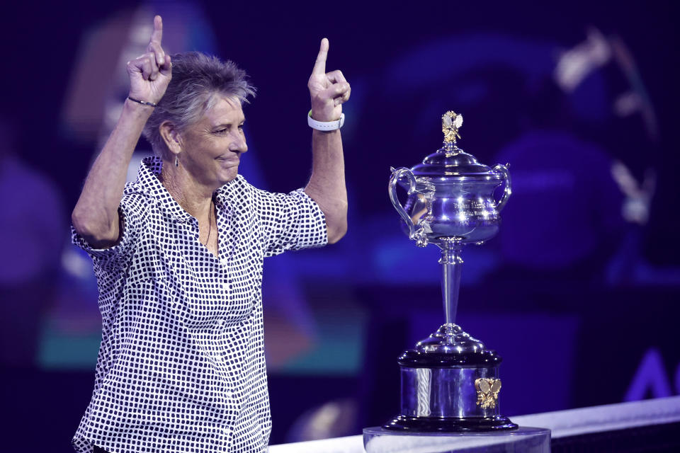 Former Australian Open women's champion Chris O'Neil gestures after taking the Daphne Akhurst Memorial Cup onto he court ahead of the final between Ash Barty of Australia and Danielle Collins of the U.S. at the Australian Open tennis championships in Saturday, Jan. 29, 2022, in Melbourne, Australia. (AP Photo/Hamish Blair)