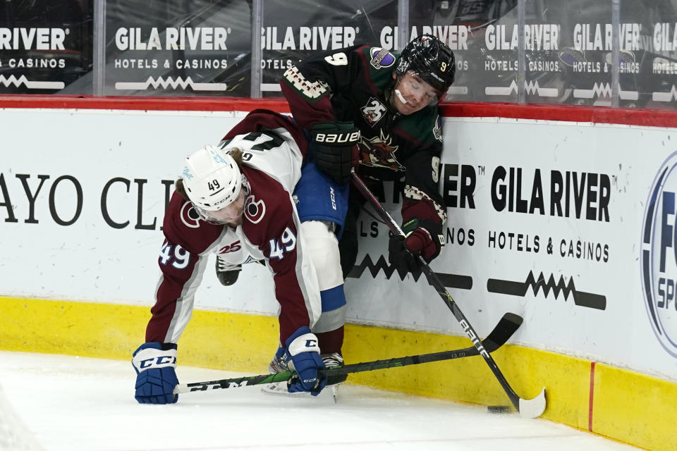 Colorado Avalanche defenseman Samuel Girard (49) and Arizona Coyotes right wing Clayton Keller battle for the puck in the second period during an NHL hockey game, Tuesday, March 23, 2021, in Glendale, Ariz. (AP Photo/Rick Scuteri)