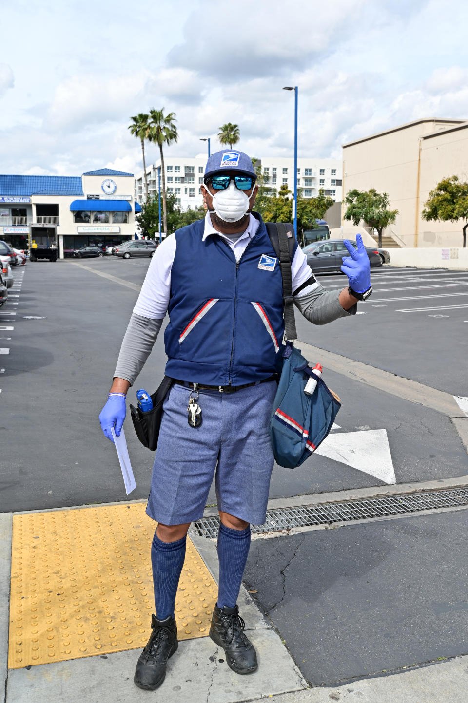 A Hollywood postal worker, dressed in protective mask and gloves, delivers the mail in Hollywood on Friday March 20th.. (Photo by Stephen Albanese/Michael Ochs Archives/Getty Images)