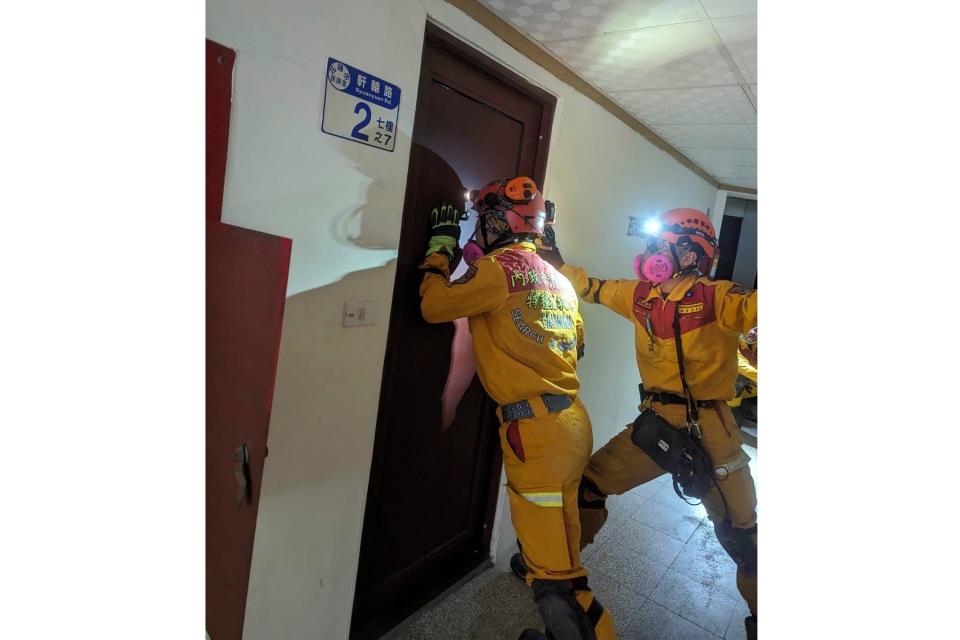 Members of a search and rescue team look for victims inside a leaning building in the aftermath of an earthquake in Hualien, eastern Taiwan (AP)