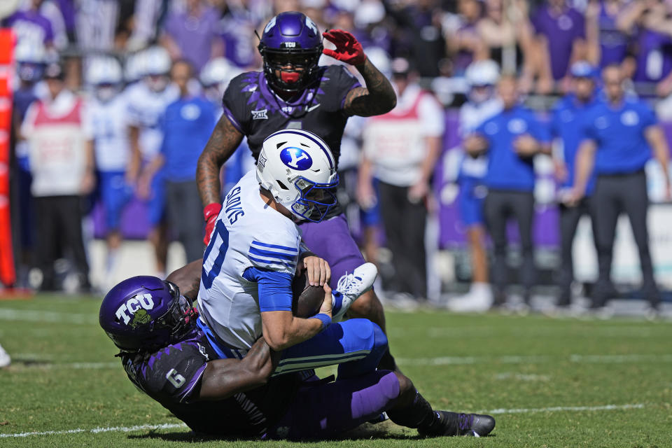 BYU quarterback Kedon Slovis (10) is sacked by TCU linebacker Jamoi Hodge (6) with linebacker Namdi Obiazor looking on during the first half of an NCAA college football game Saturday, Oct. 14, 2023, in Fort Worth, Texas. (AP Photo/LM Otero)