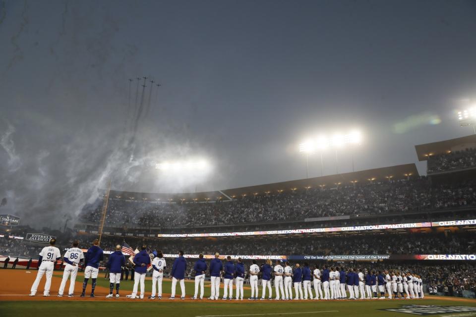 Dodgers stand for the national anthem during a flyover.