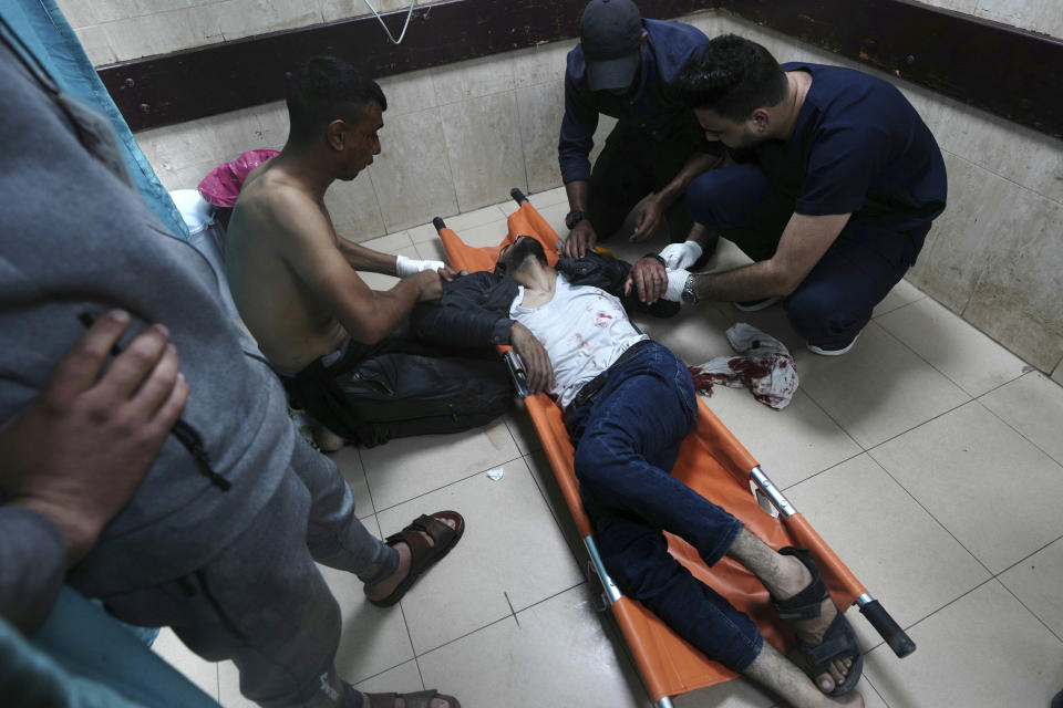 Palestinians wounded in the Israeli bombardment of the Gaza Strip are brought to a treatment room of al Aqsa Hospital on Deir al Balah, Gaza Strip, Friday, Nov. 10, 2023. (AP Photo/Adel Hana)
