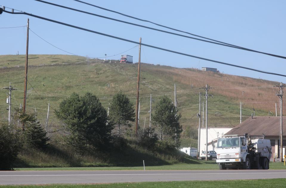 Tractor trailers can be scene coming and going, driving along the ridge of Seneca Meadows Inc. landfill that borders NY 414.