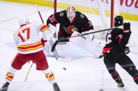 Calgary Flames left wing Milan Lucic (17) moves in on Ottawa Senators goaltender Matt Murray (30) as Senators defenceman Mike Reilly (5) gets his stick twisted up behind him during second period NHL hockey action in Ottawa on Monday, March 1, 2021. (Sean Kilpatrick/The Canadian Press via AP)