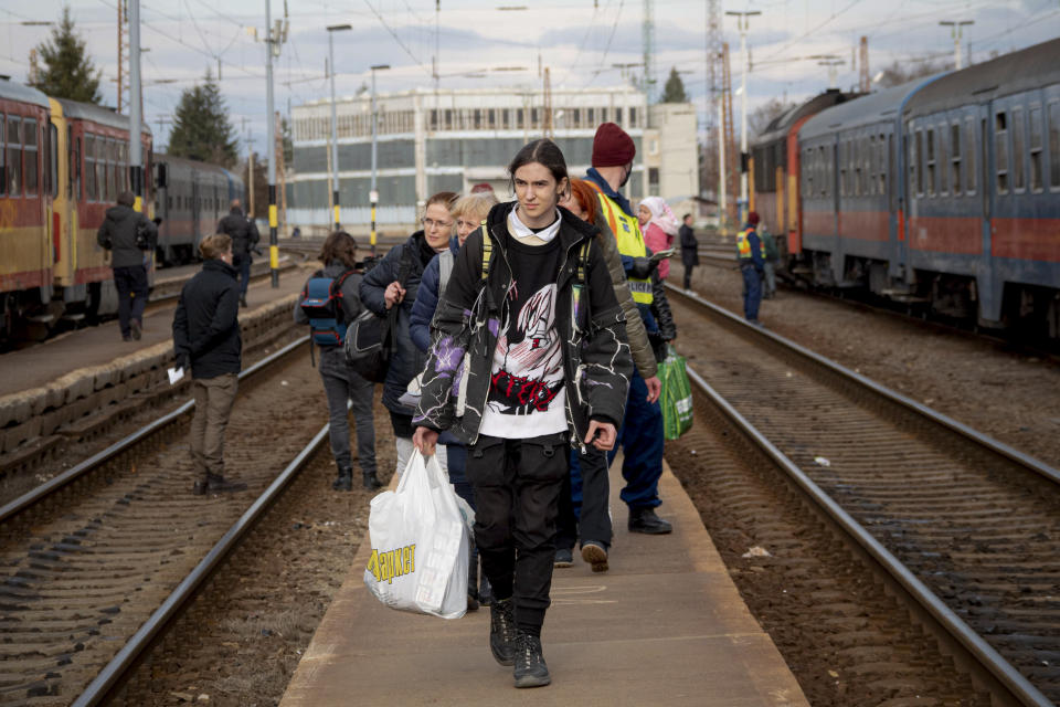 Refugees fleeing the war from neighboring Ukraine walk on a platform after disembarking from a train in Zahony, Hungary, Wednesday, March 2, 2022. At the train station in the Hungarian town of Zahony on Wednesday, more than 200 Ukrainians with disabilities — residents of two care homes in Ukraine's capital of Kyiv — disembarked into the cold wind of the train platform after an arduous escape from the violence gripping Ukraine. (AP Photo/Balazs Kaufmann)