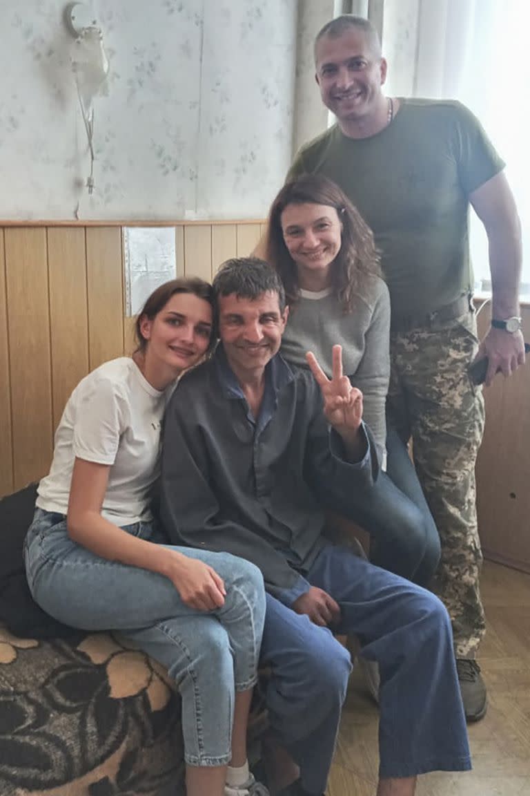El soldado ucraniano Mykhailo Dianov, en el centro, que fue liberado en un intercambio de prisioneros entre Rusia y Ucrania, rodeado de amigos y familiares en un hospital en Ucrania, el jueves 22 de septiembre de 2022. 