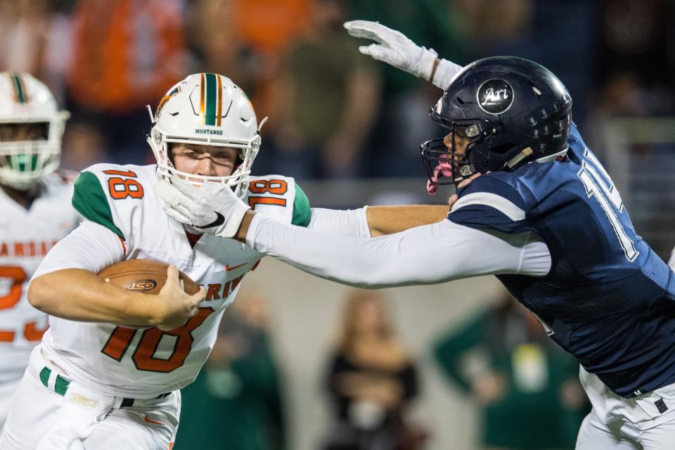 Mandarin quarterback Carson Beck (18) stiff-arms Miami Columbus defensive end Elijah Roberts (14) during the 2018 Class 8A championship. Mandarin and Columbus meet again Friday, five years to the day after the Mustangs' first state title.