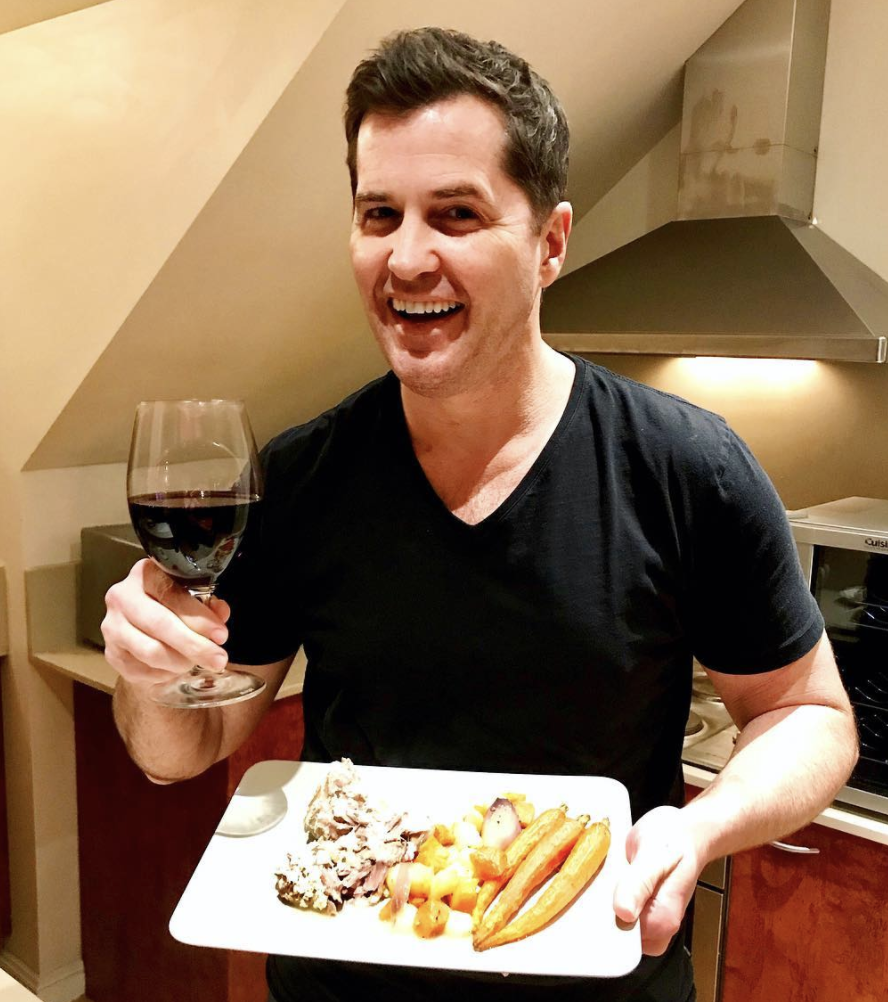 Ryan Phelan holding a plate of food and glass of wine. Source: Instagram