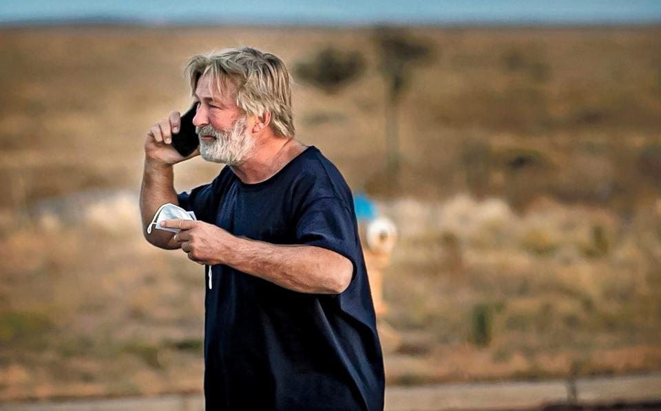 Alec Baldwin speaks on the phone in the parking lot outside the Santa Fe County Sheriff's Office in Santa Fe, N.M., after he was questioned about a shooting on the set of the film "Rust" on the outskirts of Santa Fe, Thursday, Oct. 21, 2021. Baldwin fired a prop gun on the set, killing cinematographer Halyna Hutchins and wounding director Joel Souza, officials said. (Jim Weber/Santa Fe New Mexican via AP) - AP