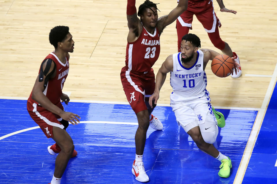 Kentucky's Davion Mintz (10) looks for help while defended by Alabama's John Petty Jr. (23) and Jordan Bruner, left, during the second half of an NCAA college basketball game in Lexington, Ky., Tuesday, Jan. 12, 2021. (AP Photo/James Crisp)