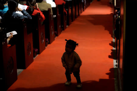 A girl plays as believers take part in a weekend mass at Beijing South Catholic Church, a government-sanctioned Catholic church, in Beijing, China September 29, 2018. REUTERS/Jason Lee