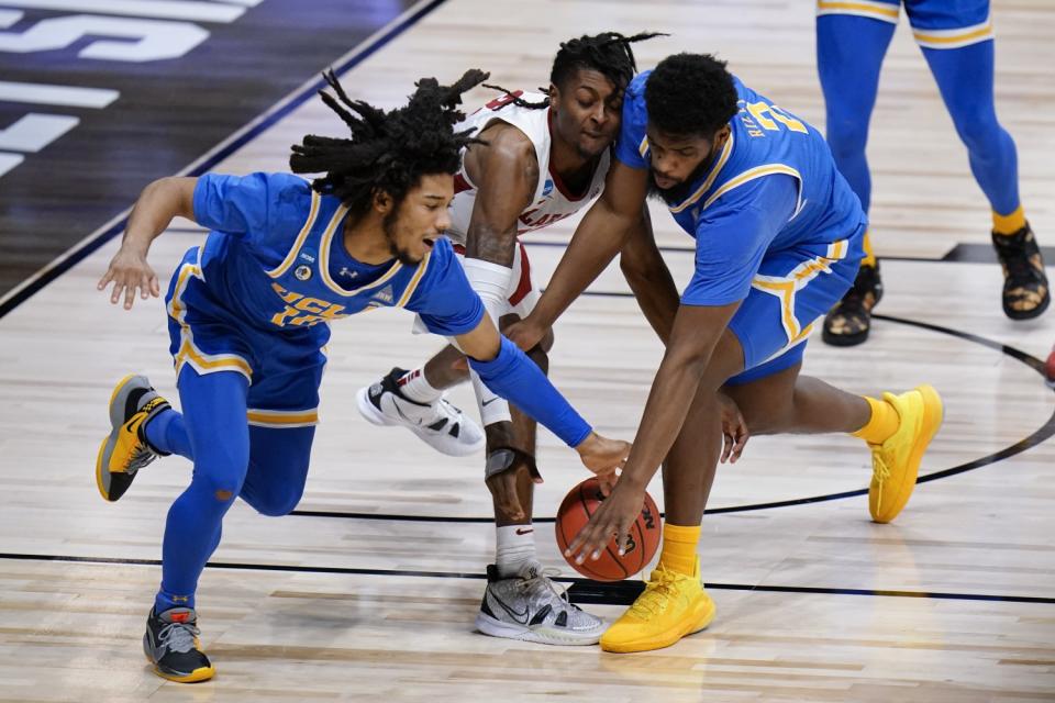 UCLA guard Tyger Campbell (10) and Cody Riley (2) battle Alabama guard John Petty Jr. for a loose ball.