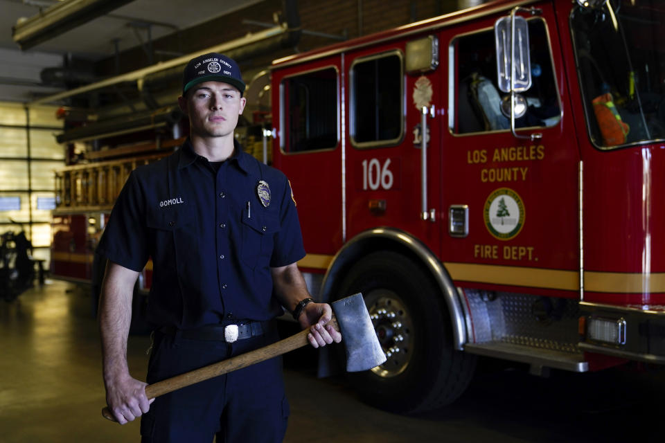 Fire engine probationary firefighter Cole Gomoll of Los Angeles County Fire Department - Station 106 poses for a photo with a flathead ax at his station Friday, Feb. 26, 2021, in Rancho Palos Verdes, Calif, a suburb of Los Angeles. He used the ax to cut away the windshield of a vehicle crashed by golfer Tiger Woods on Tuesday. (AP Photo/Ashley Landis)