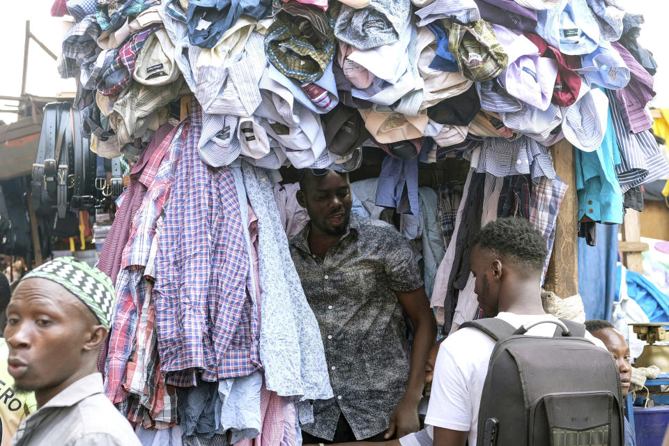 A seller of second hand clothes interacts with a customer at Owino Market in Kampala, Uganda, Friday, Sept. 15, 2023. Downtown Kampala’s Owino Market has long been a go-to enclave for rich and poor people alike looking for affordable but quality-made used clothes, underscoring perceptions that Western fashion is superior to what is made at home. But, despite their popularity, secondhand clothes are facing increasing pushback. (AP Photo/Hajarah Nalwadda)