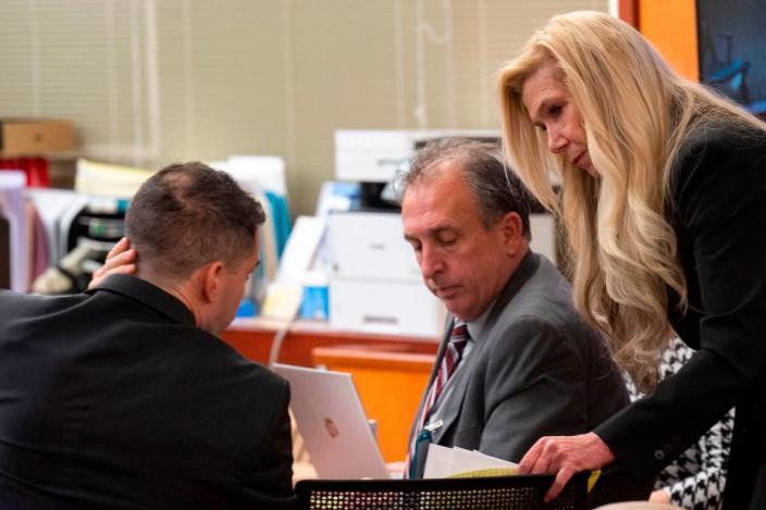 Defense attorneys Nick Gross (left) and Anne Bremner talk about questioning former Tacoma Police Department officer Corey Ventura as Pierce County Sheriff looks on during Bremner’s cross-examination of Ventura on Thursday, Dec. 1, 2022, at Pierce County District Court in Tacoma.