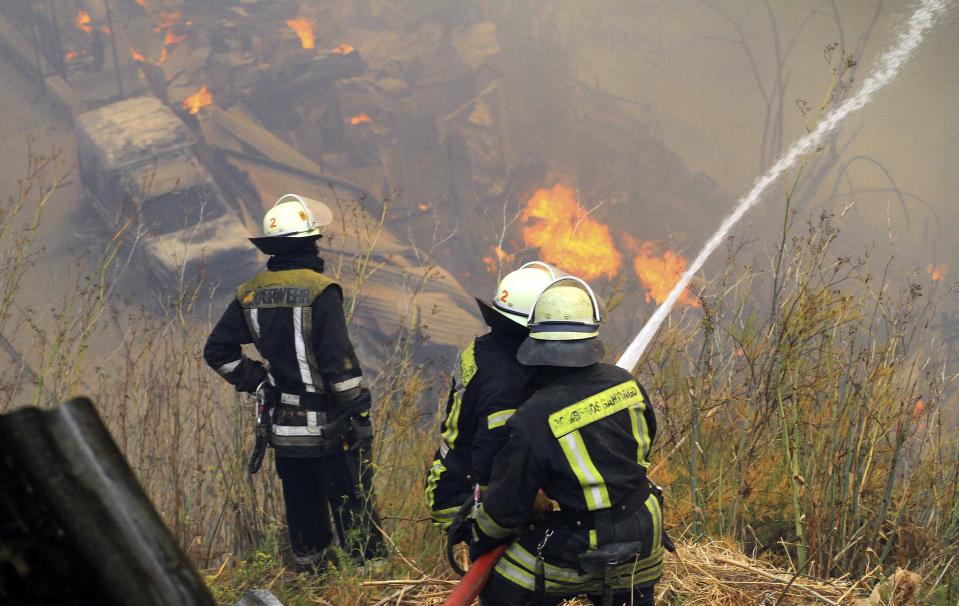 Firefighters work to put down a fire at the location where a forest fire burned several neighbourhoods in the hills in Valparaiso city, northwest of Santiago, April 13, 2014. At least 11 people were killed and 500 houses destroyed over the weekend by the fire that devastated parts of the Chilean port city of Valparaiso, as authorities evacuated thousands and sent in aircraft to battle the blaze. REUTERS/Carlos Gutierrez (CHILE - Tags: SOCIETY ENVIRONMENT DISASTER)