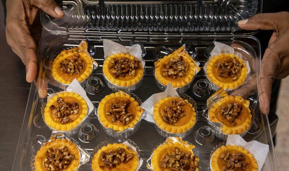 Linda Smith-Cummings, the owner of Soul Amazing LLC, holds a batch of her signature sweet potato pies with a pecan topping inside the North Rosedale Park Community House kitchen in Detroit on Wednesday, Nov. 16, 2022. 