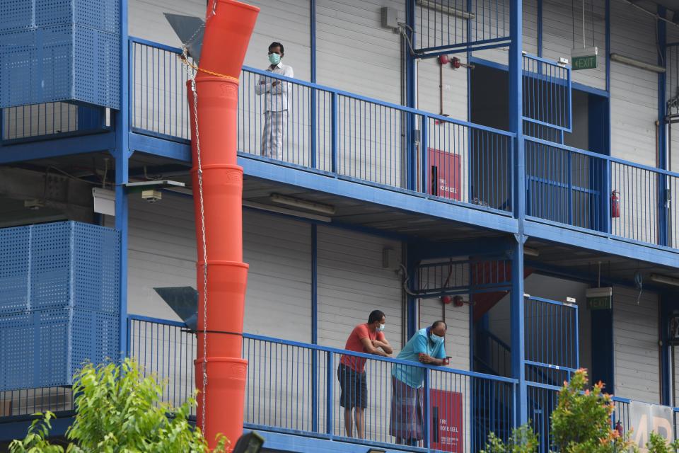 Migrant workers wearing face masks at a quarantined dormitory building in Singapore. 