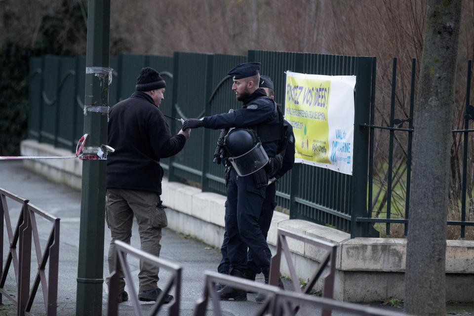 A riot police officer checks a badge after a man attacked passerby Friday Jan.3, 2020 in Villejuif, south of Paris. A man armed with a knife rampaged through a Paris park attacking passers-by seemingly at random Friday, killing at least one person and injuring two others before police shot him dead, officials said. (AP Photo/Michel Euler)